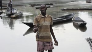 One Of The Villagers Displaying Dead Fish Killed By The Spillage